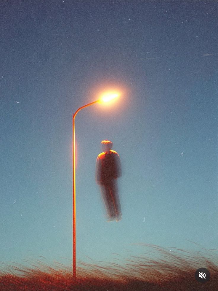 A dreamlike figure floating beneath an amber streetlight in a blue evening sky.